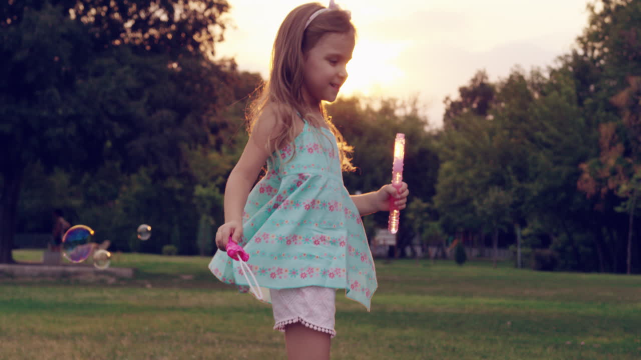 작은 소녀가 거품으로 놀고 있습니다.