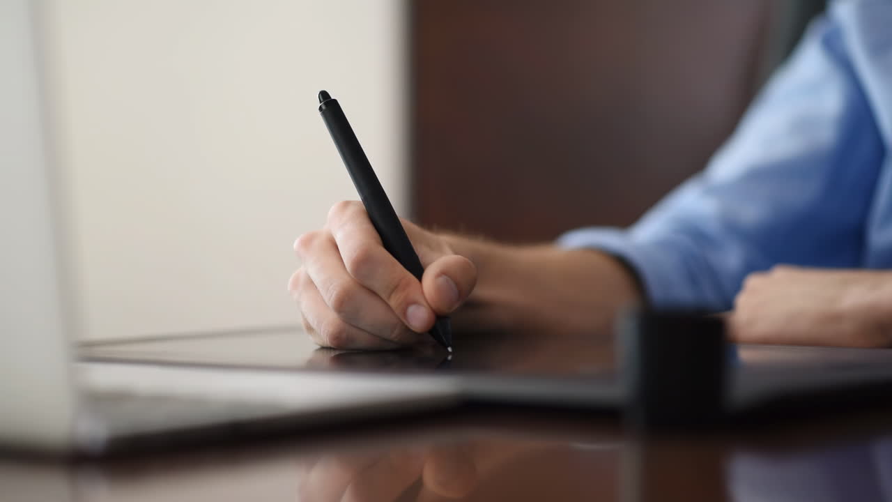 Man drawing on a pen tablet in the office. Close-up shot