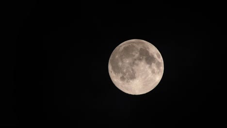 Clouds-passing-by-the-full-moon,-real-time-shot