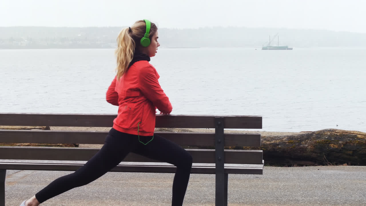 mujer realizando ejercicios de estiramiento en la orilla del mar 4k