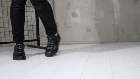 male model moving and dancing in the studio. cropped image of a man demonstrating comfortable black leather sport shoes.