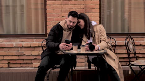 una pareja de turistas caucásicos sentados en una cafetería al aire libre.