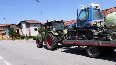 tractor towing machinery through a residential area