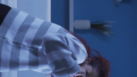 겁쟁이 표정으로 카메라를 바라보는 여성의 수직 비디오.