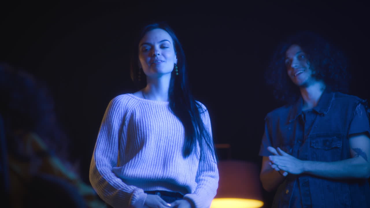 Group of friends socializing in a dimly lit night club or party