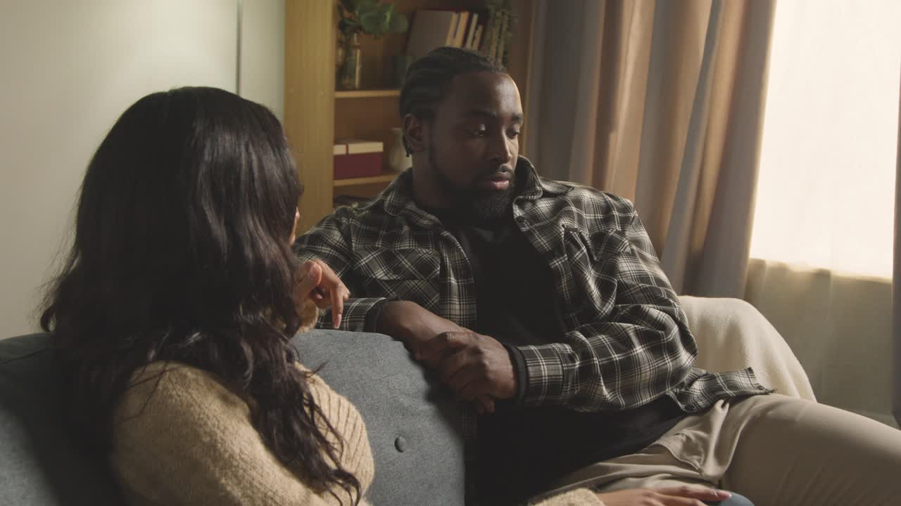 Young Couple Relaxing At Home Sitting On Sofa Talking Together 1