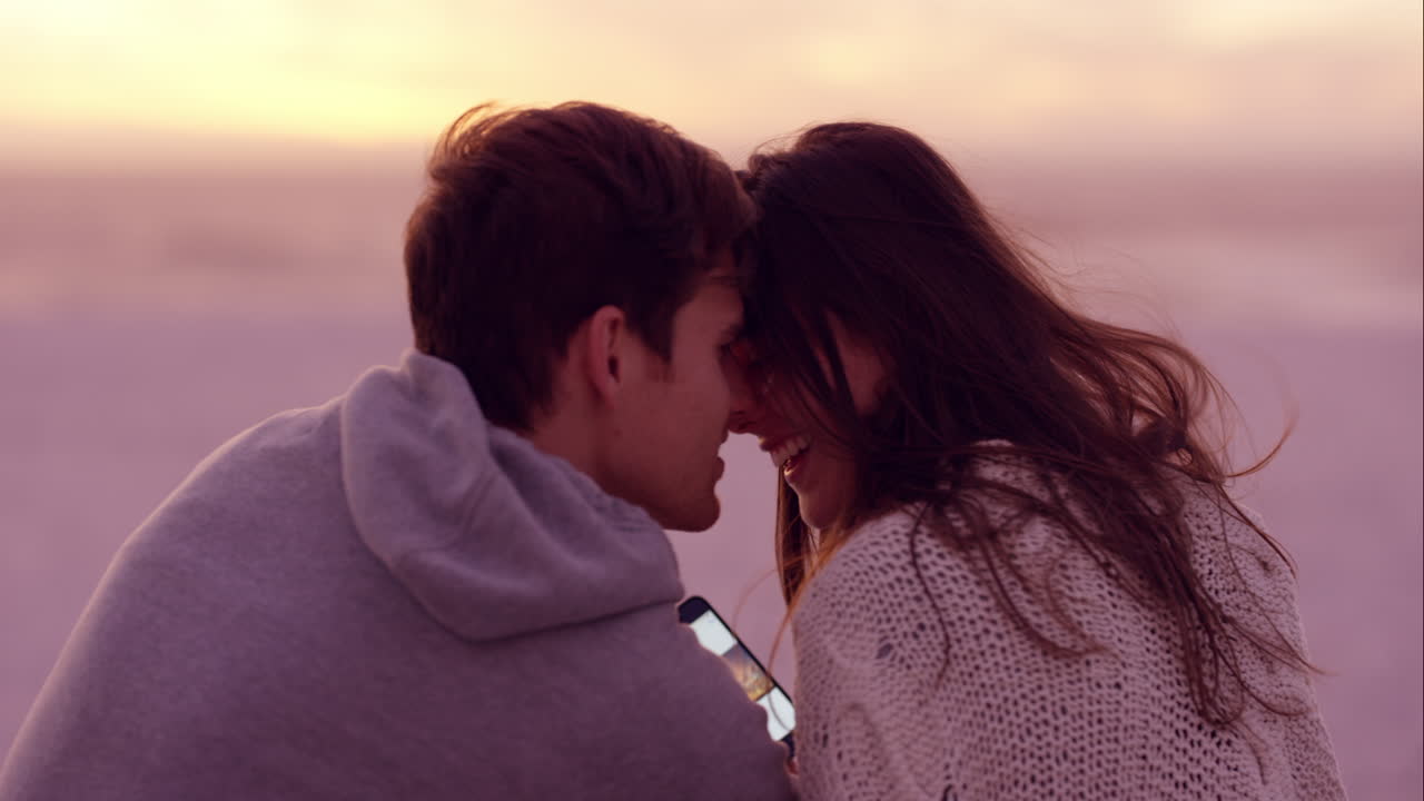 해변 에서 일몰 을 즐기는 부부