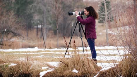 female photographer taking pictures during cold winter day