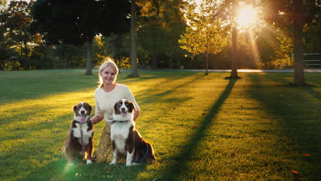 Herbstspaziergang-Im-Park-Mit-Zwei-Haustieren-Frau,-Die-Mit-Ihren-Hunden-Spazieren-Geht