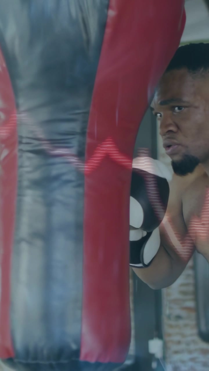 Vertical video: Boxer approaching bag and throwing short jabs while waveform data tracking fitness