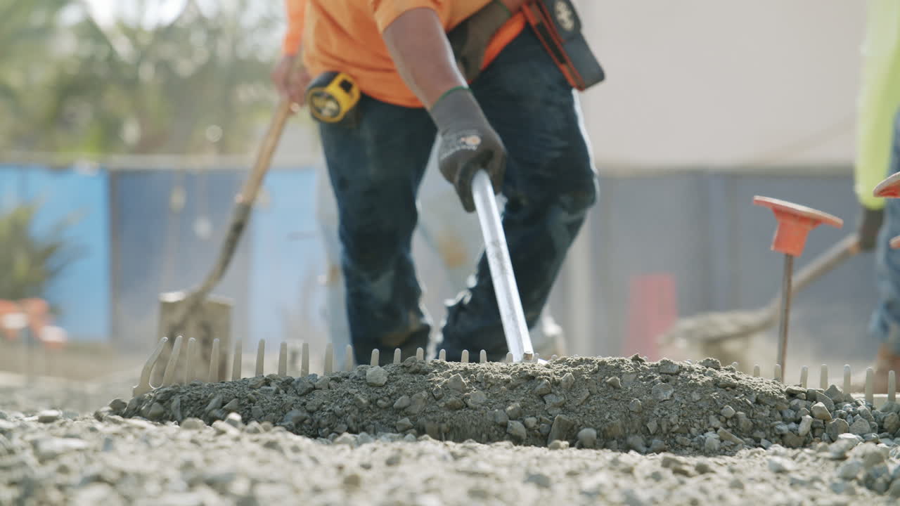 Construction Workers Spreading Concrete at a Job Site