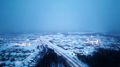 aerial 4k sunrise blue hour morning cinematic 4k blizzard snowfall foggy glowing drone shot of arctic winter community isolated remote mining village hub of the north thompson manitoba canada