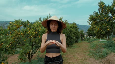 woman eating an orange in an orchard