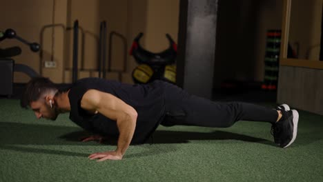 hombre de fitness fortaleciendo el músculo del brazo con flexiones durante un entrenamiento intenso en el gimnasio
