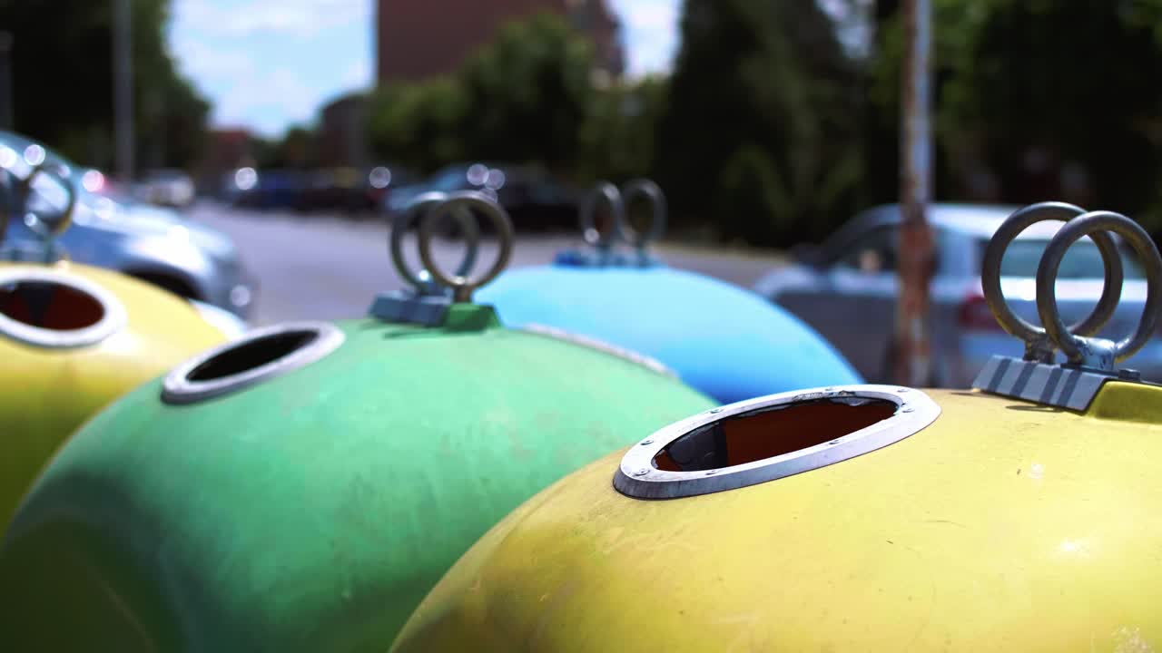 Man&rsquo;s hand throwing plastic, empty bottle into recycling bin