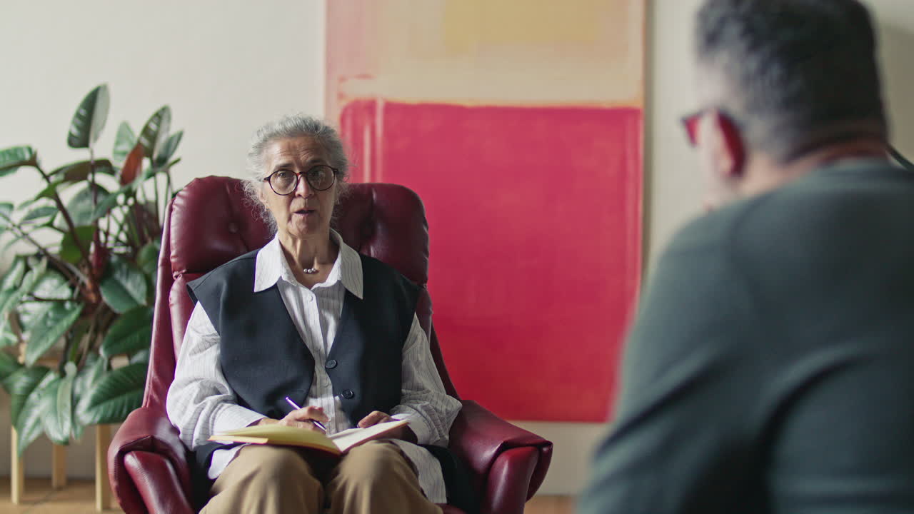 Elderly Therapist Offering Advice to Male Client during Psychology Consultation