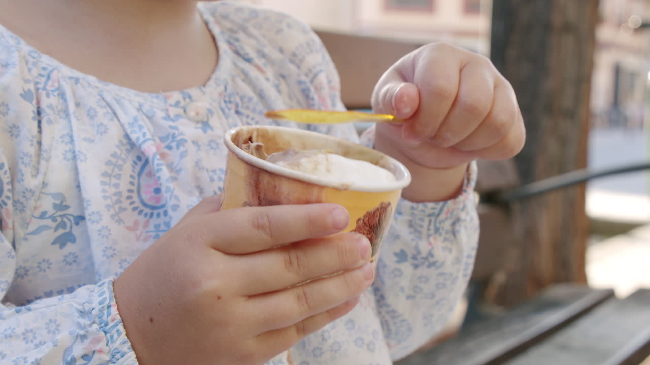 niña pequeña disfrutando de helado al aire libre