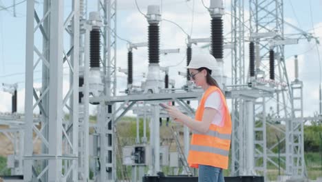 un empleado de ingeniería hace un recorrido e inspección de una subestación eléctrica moderna. energía.