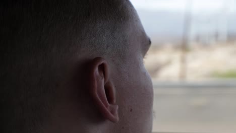 side view of a young man looking straight on the road while driving a car - closeup shot, handheld