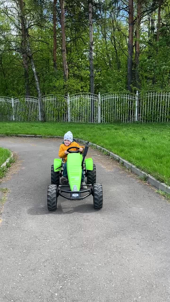 Boy riding a pedal tractor in the park