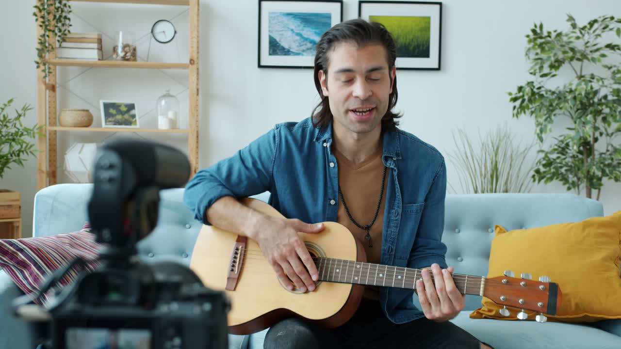 hombre tocando la guitarra acústica en casa