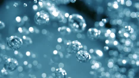 many water bubbles in blue water close up, abstract water wave with bubbles in slow motion.