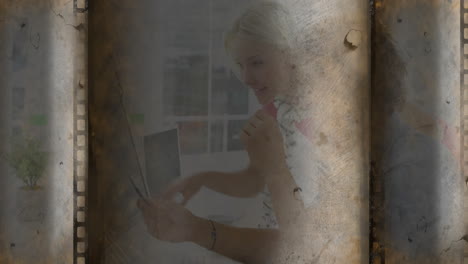 using tablet, person creating animation over vintage filmstrip in school setting