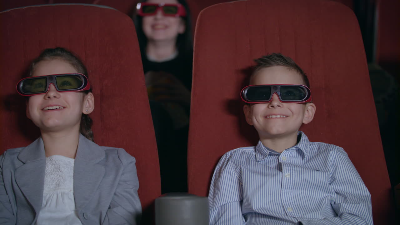 niños con gafas 3d viendo películas en el cine