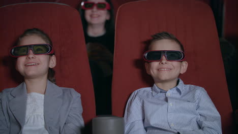 children in 3d glasses watching movie in the cinema