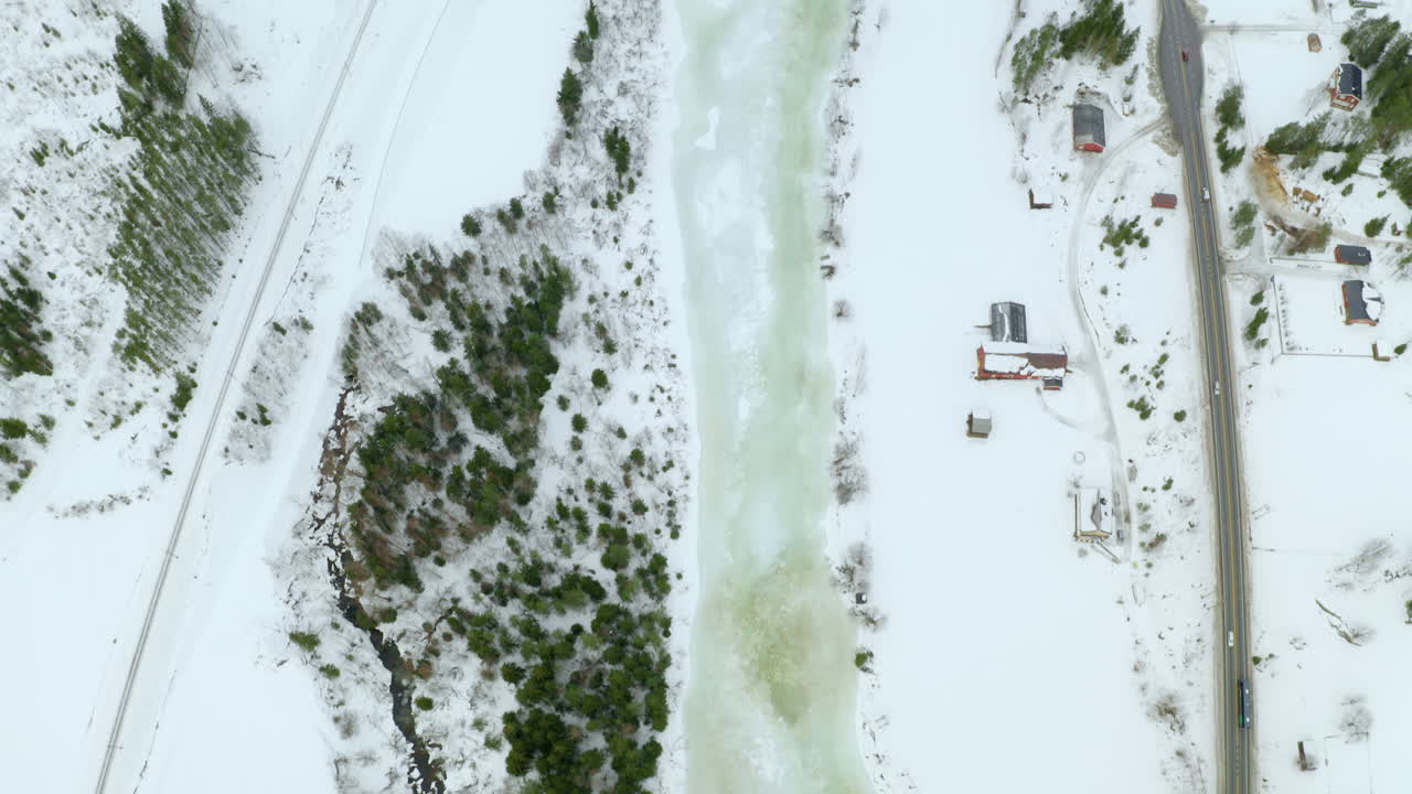 río congelado que fluye entre el bosque y el pueblo en haugastol en invierno en noruega