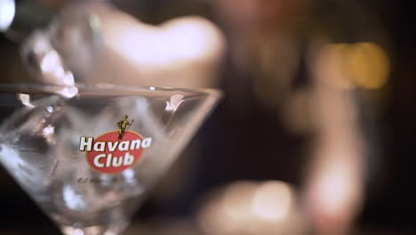 close up of a cocktail glass, bartender making a cocktail pouring ice cubes and alcohol at havana cuba