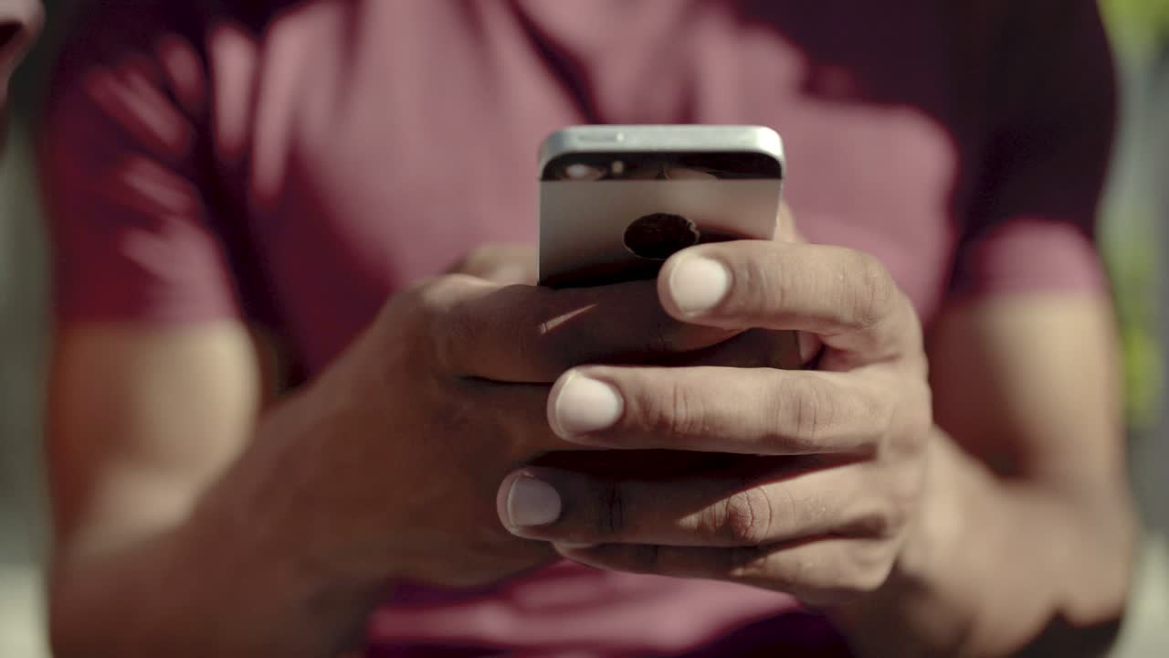 Primo piano di mani maschili che digitano un messaggio sullo smartphone