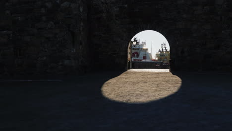 view of the sea port through the arch of the ancient fortress wall the shadow creates a beautiful ov