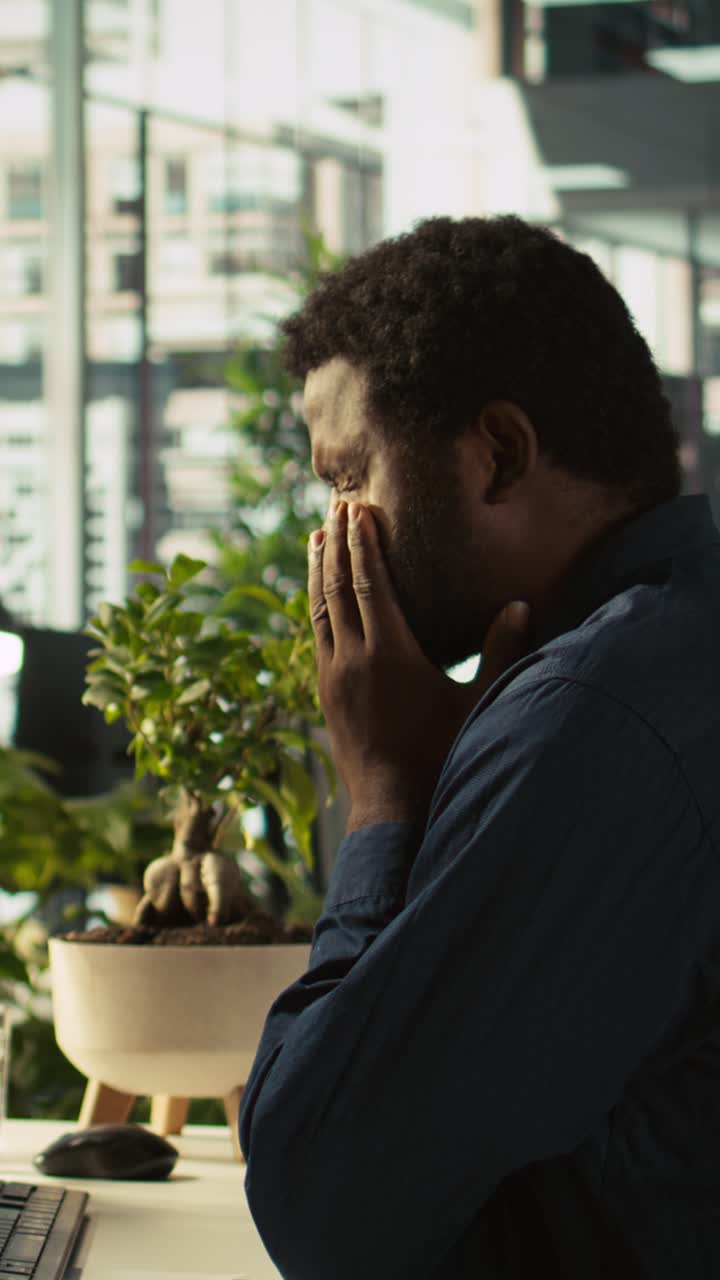 Vertical video Worker feeling painful headache while working, suffering burnout