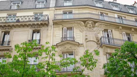 haussmann style building with unique caryatid angel on exterior facade