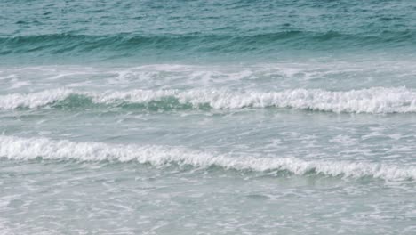 Small-waves-crashing-on-the-beach-in-slow-motion