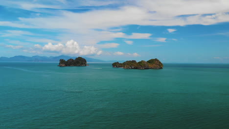 boat sailing by two amazing mountainous islands, pulau gasing and pulau pasir