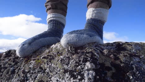 feet in socks standing on a rock in a winter landscape