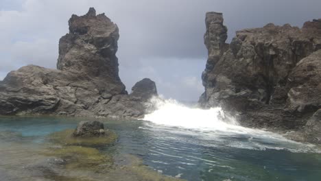 las ondas enérgicas chocan contra las rocas y rompen en la calle