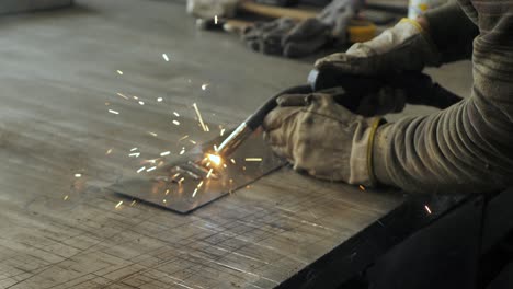 welder on the table welds a set of metal parts