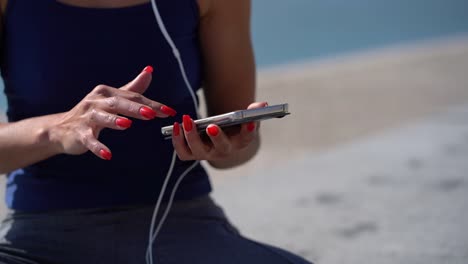 Toma-Recortada-De-Una-Chica-En-Ropa-Deportiva-Usando-Un-Teléfono-Móvil.