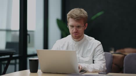 freelancer man is working with notebook in cafe or restaurant in daytime, coworking area for remote work