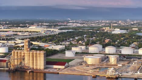 industrial tanks and silos line the waterfront in tampa, florida, near major highway overpasses. aerial perspective of the industrial zone.