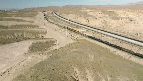 long freight train traveling through state of nevada in usa - aerial drone shot