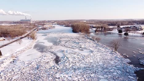 Bloqueo-De-Hielo-En-Primer-Plano-En-El-Río-Pasas-De-La-Ciudad-De-Monroe,-Michigan,-Estados-Unidos-Con-Vistas-A-La-Planta-De-Energía-De-Carbón-De-Monroe