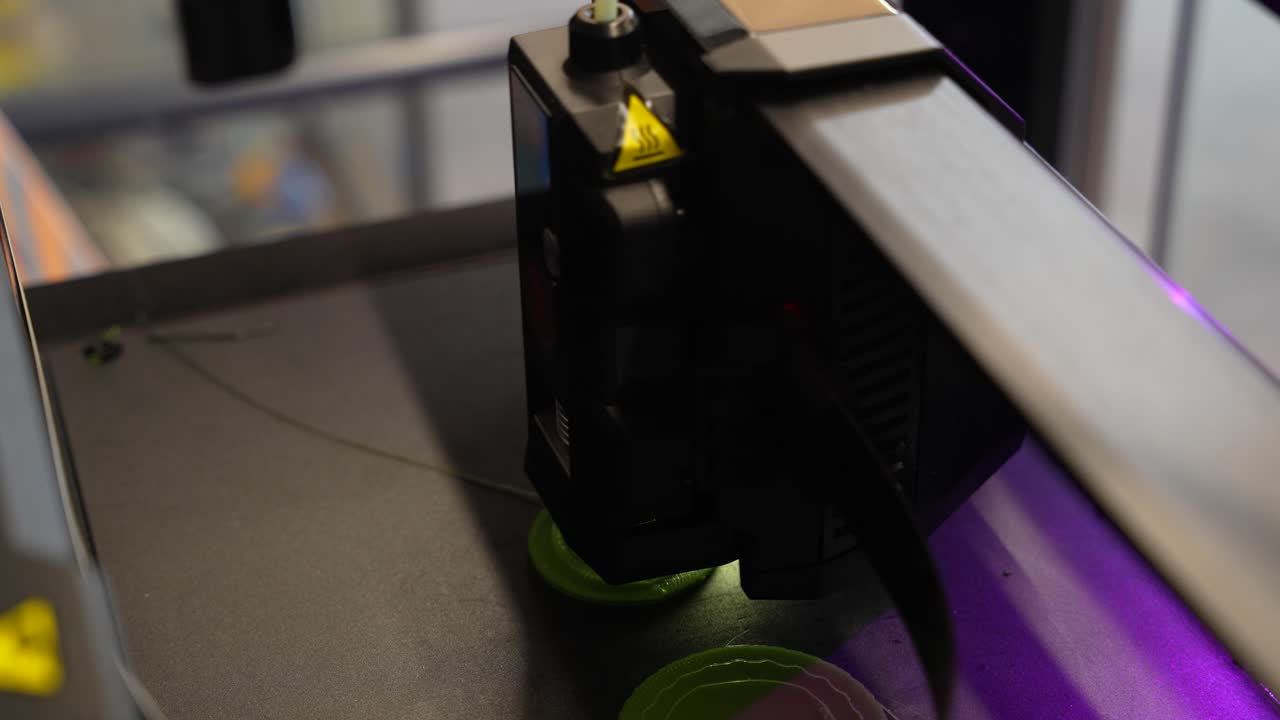 3D printer in action creating an object from molten plastic