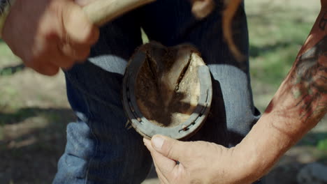 Man-puts-on-new-horseshoe-with-hammer-and-nails