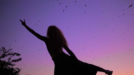 Una-Hermosa-Mujer-Bailando-Al-Ritmo-De-La-Naturaleza-Y-Alcanzando-El-Cielo-Púrpura---Tiro-De-ángulo-Bajo