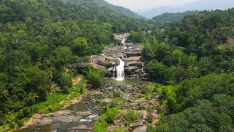 aerial drone shot of the serene waterfall in munnar amidst the lush greenery