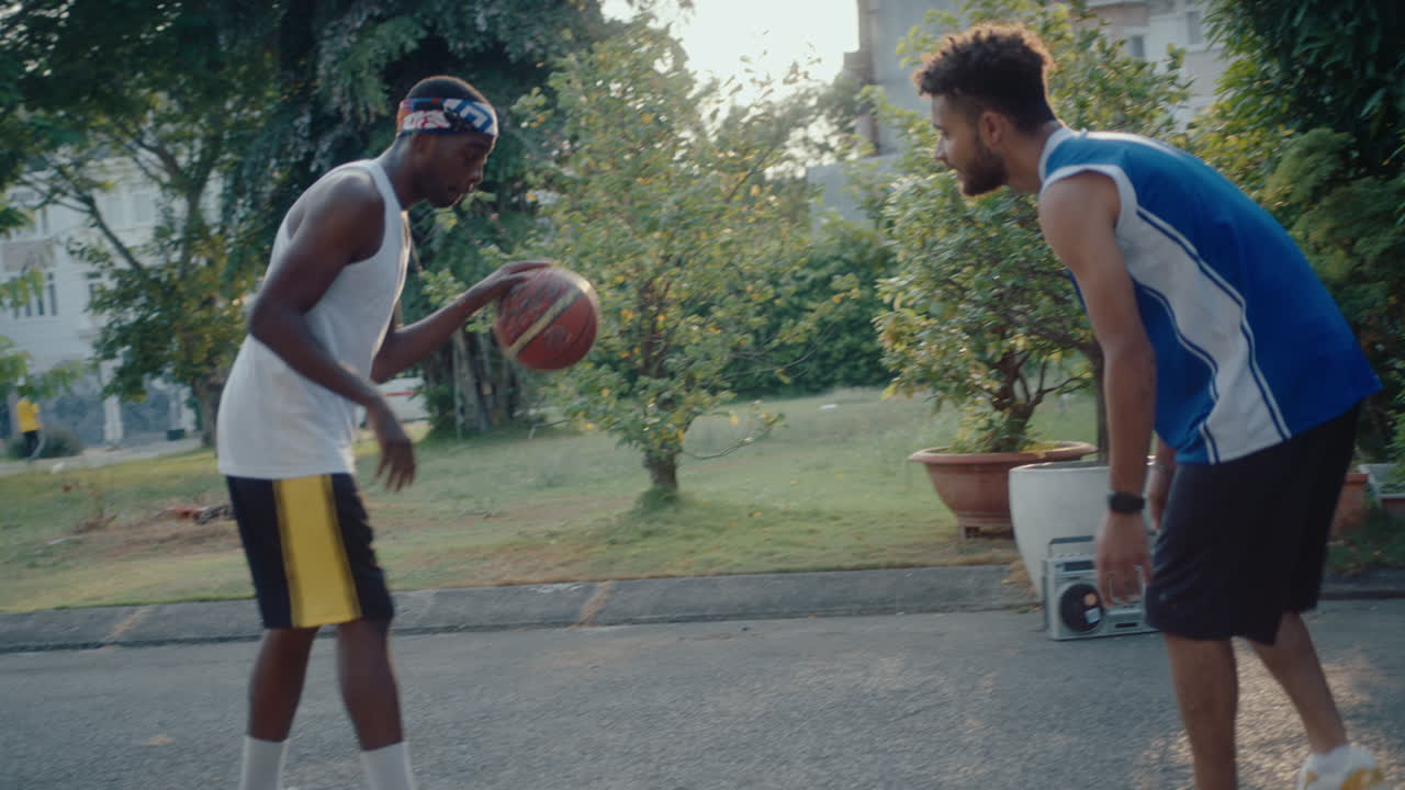Two Young Friends Playing Basketball and Having Fun Outdoors